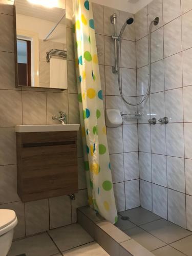 萨摩斯Hotel Anthousa的浴室设有淋浴帘、卫生间和水槽