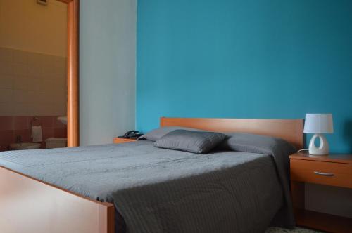 斯卡莱阿B&B Scalea Rooms的蓝色墙壁间的一张床位