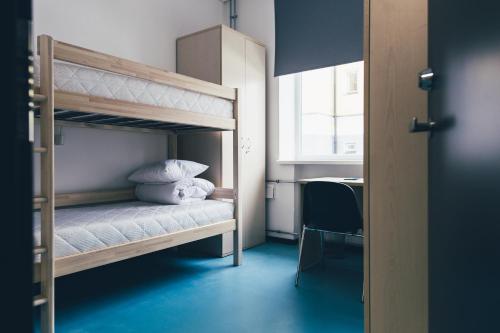 塔林Ülemiste Airport Hostel的一间卧室配有带白色床单和枕头的双层床