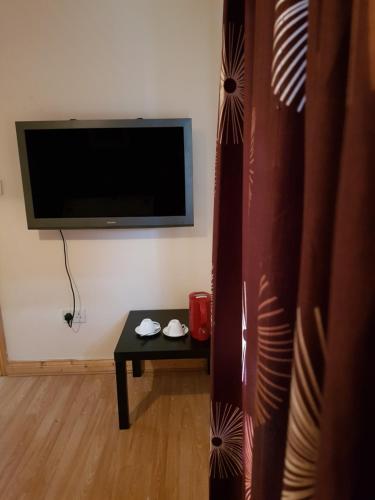 克劳道金阿什米尔旅馆 的客厅配有桌子和平面电视。