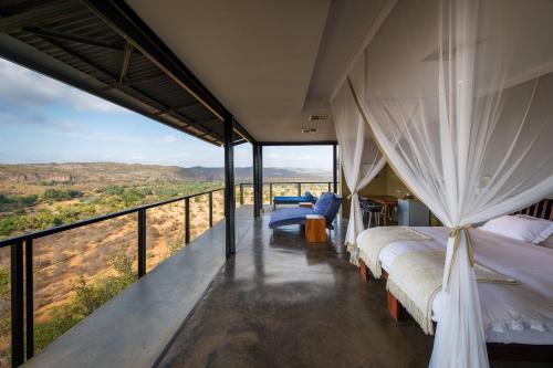 Makuleke Contract ParkThe Outpost & Pel's Post的一间卧室设有床铺和一个美景阳台