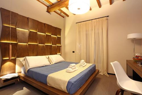 罗马Unicum Vite的一间卧室配有一张带木制床头板的床