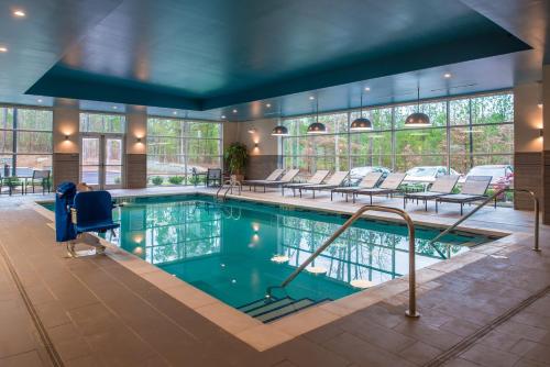 罗利罗利/达拉姆/布赖尔溪凯悦酒店的大楼内带桌椅的大型游泳池