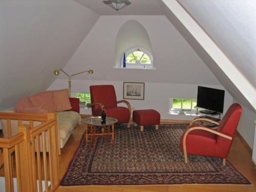 尼布卢姆Föhrer Friesenkate Ost的客厅配有红色椅子和沙发