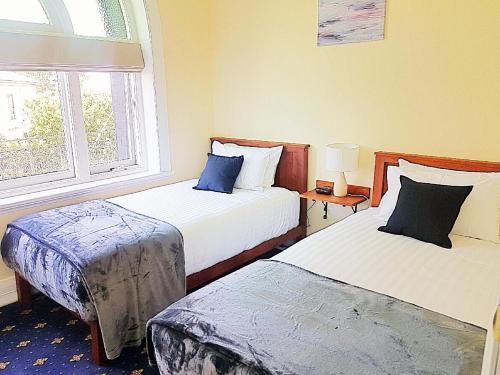 温耶德码头酒店的酒店客房设有两张床和窗户。