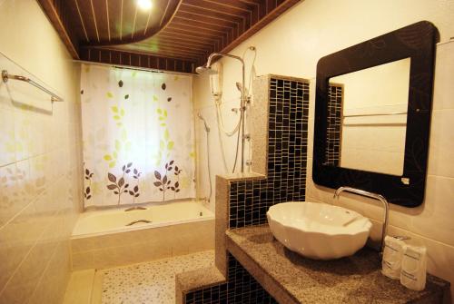 高兰兰塔自然海滩度假村的一间带水槽、淋浴和镜子的浴室
