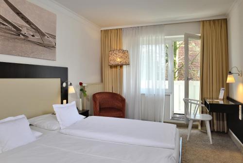 Sankt MichaelisdonnDer Kleine Hans的配有一张床、一张书桌和一扇窗户的酒店客房