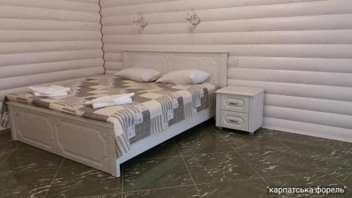 斯瓦拉瓦Karpatska Forel的一张带两个枕头的床和一个床头柜