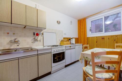 木洛希尼Apartman Dragica的厨房配有炉灶、水槽和桌子
