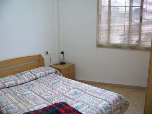 纳瓦哈斯切洛公寓的一间卧室设有一张床和一个窗口