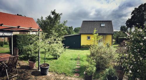 韦森贝格Gästehaus A+C Bovet的后院,有黄色的房屋和树木
