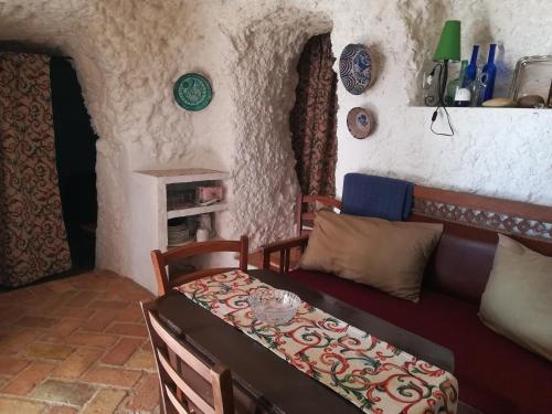 PegalajarCueva El Madrono的客厅配有沙发和1张床