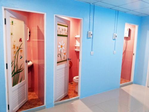 芭东海滩芭东旺旺旅舍的浴室拥有蓝色和粉红色的墙壁,设有卫生间