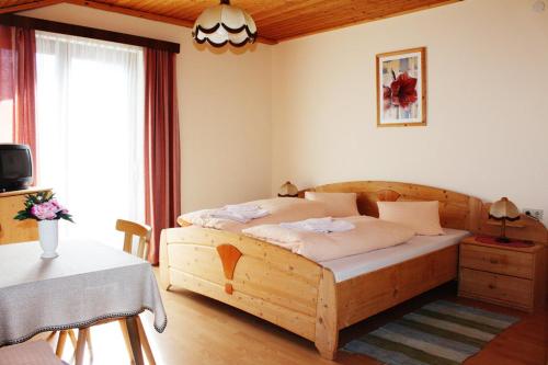 伯恩鲍姆艾德维斯霍夫酒店的一间卧室配有一张木床和一张桌子