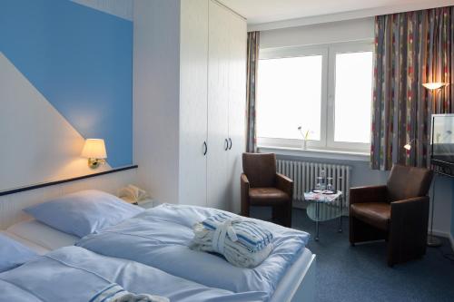 诺德奈沃特斯特朗艾尔斯酒店的一间卧室配有一张床、两把椅子和一个窗户