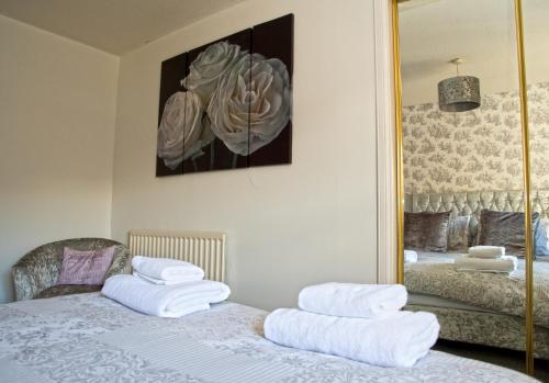艾尔No5 Ayr Beach - Coorie Doon Stays的一间卧室配有一张带白色毛巾的床