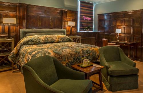 斯坦福德斯坦福乔治酒店的一间卧室配有一张床、两把椅子和一张桌子