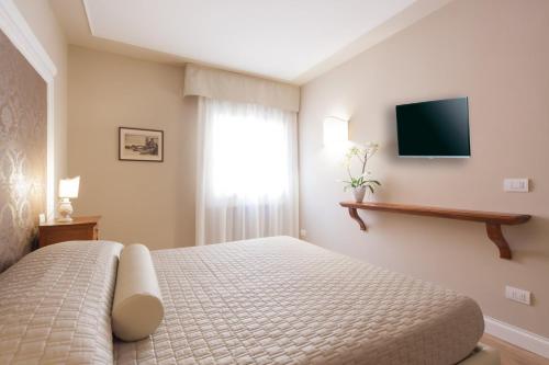 维罗纳佩拉公寓的一间卧室配有一张床,墙上配有电视
