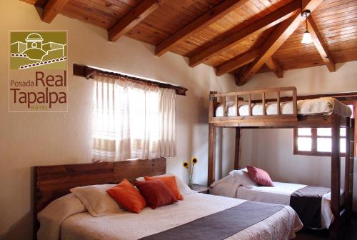 塔帕尔帕Hotel Posada Real Tapalpa的带木天花板的客房设有两张双层床。