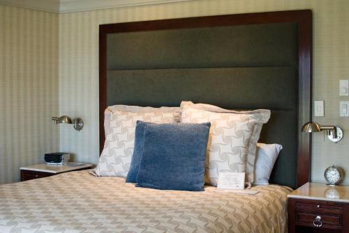 蒙特雷蒙特利湾酒店的一间卧室配有一张带蓝色枕头的大床