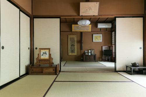 高山寿美吉旅馆的一间设有白色门和地毯的走廊的客房