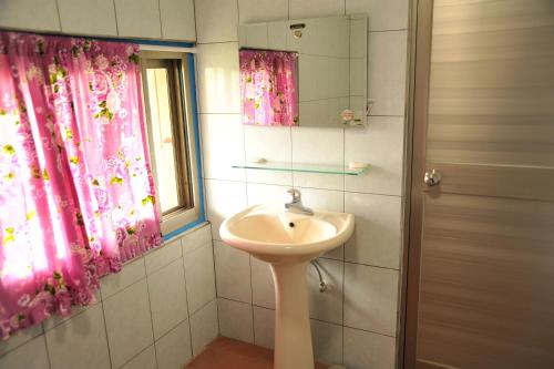 富里丰南小田庄的一间带水槽的浴室和一个带粉红色窗帘的窗户