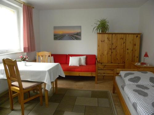 奥拉宁堡Ferienwohnungen Pilke的客厅配有红色的沙发和桌子