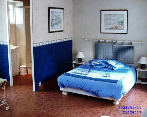 AmblieL'eau vive的一间卧室配有一张带蓝色棉被的床
