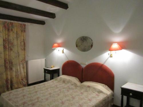 派莱卡斯黎凡特酒店的一间卧室配有一张带红色床头板的床和两盏灯。