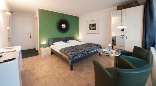 Haut-VullyLe Mont-Vully - Hôtel Restaurant的一间卧室设有一张床和绿色的墙壁