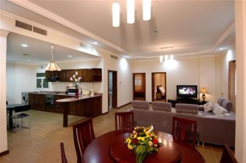 麦纳麦苎麻套房公寓4的客厅以及带桌子和沙发的厨房。