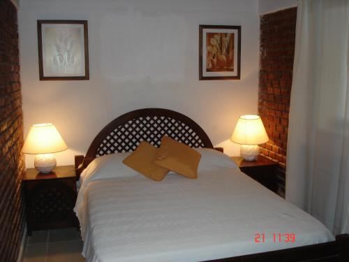 帕特拉德拉帕特拉Palmares Del Paso的一间卧室配有一张带两张台灯的床铺。