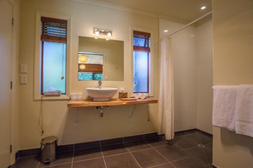 塔卡卡岩石小屋酒店的一间带水槽的浴室和两个窗户