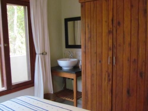 Ponta MalanganeNkumbe Bush Retreat Family Home的一间带水槽和木制橱柜的浴室