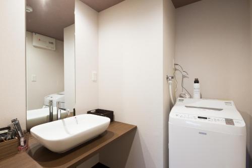 京都Kyoto Riverview House Kyoraku的一间带水槽和洗衣机的浴室