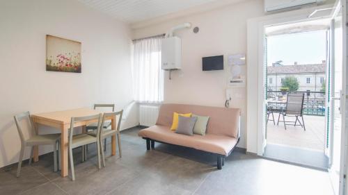 佩斯基耶拉德加达Fiori sull'Acqua Apartments的客厅配有桌子和椅子