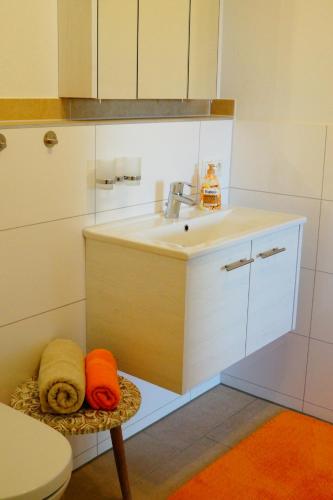 奥格斯堡奥古斯塔逃遁公寓的厨房配有水槽和带毛巾的凳子