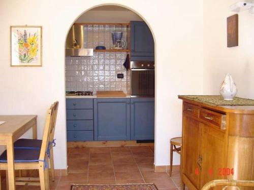 CarmineCasetta al Lago的厨房配有蓝色橱柜和木桌