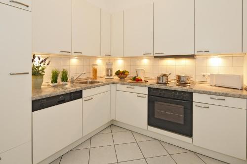 岑平Residenz Waldhaus_05的白色的厨房配有白色橱柜和电器