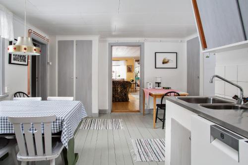 韦斯特罗斯Ängsö Fishermans Cottage的厨房、带桌子的用餐室、厨房以及用餐室