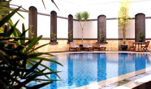 沙马林达瑞雅婆罗洲三马林达酒店的大楼内一个带桌椅的游泳池