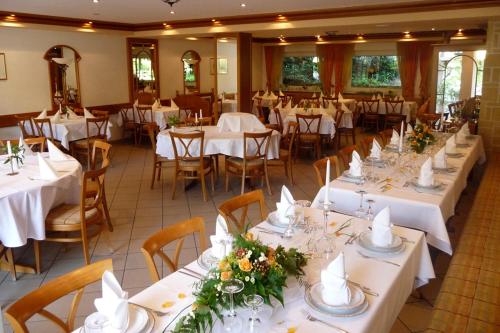 BöllenbornGasthof Waldeslust的宴会厅配有白色的桌椅