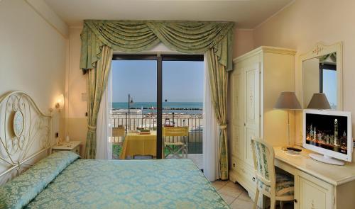 贝拉里亚-伊贾马里纳Hotel Bridge的一间卧室配有一张床、一张书桌和一个窗户。