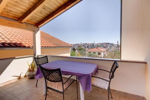 木洛希尼Apartmani Dorita的阳台配有紫色的桌椅