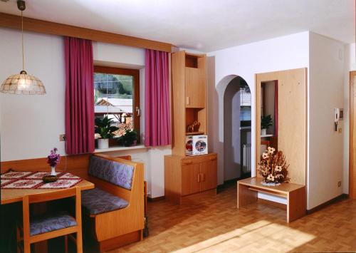 瓦尔奥纳的圣乔凡尼Appartement Wasserer的一间带桌子的客厅和一间餐厅