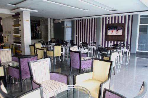 马普托Hotel Monte Carlo的用餐室配有桌椅和紫色椅子