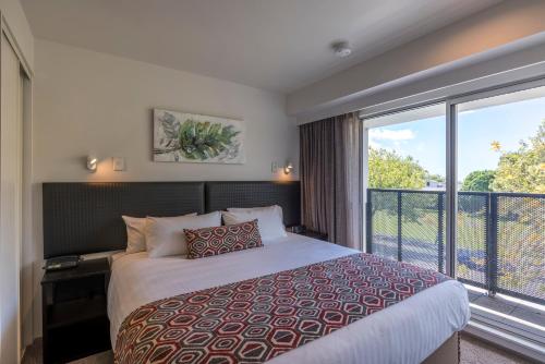 奥克兰奎斯特庞森比服务式公寓酒店的一间卧室设有一张床和一个大窗户