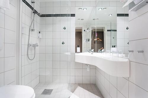 克里斯蒂安桑Dyreparken Safarihotell的白色的浴室设有水槽和淋浴。