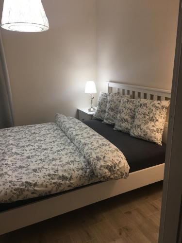 里沃Apartamenty AMALIA的一间卧室配有一张床和一张桌子上的台灯