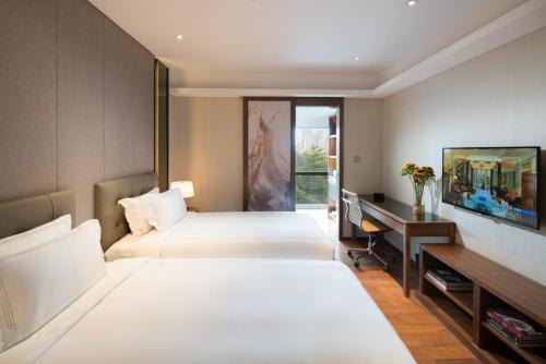 深圳深圳辉盛阁国际公寓的酒店客房配有两张床和一张书桌